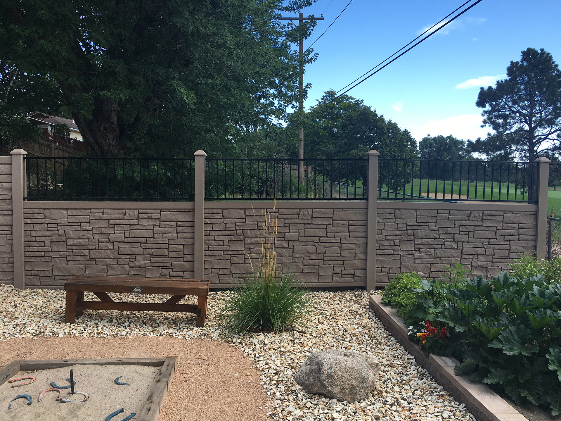 Custom brown granite simtek fence in a backyard