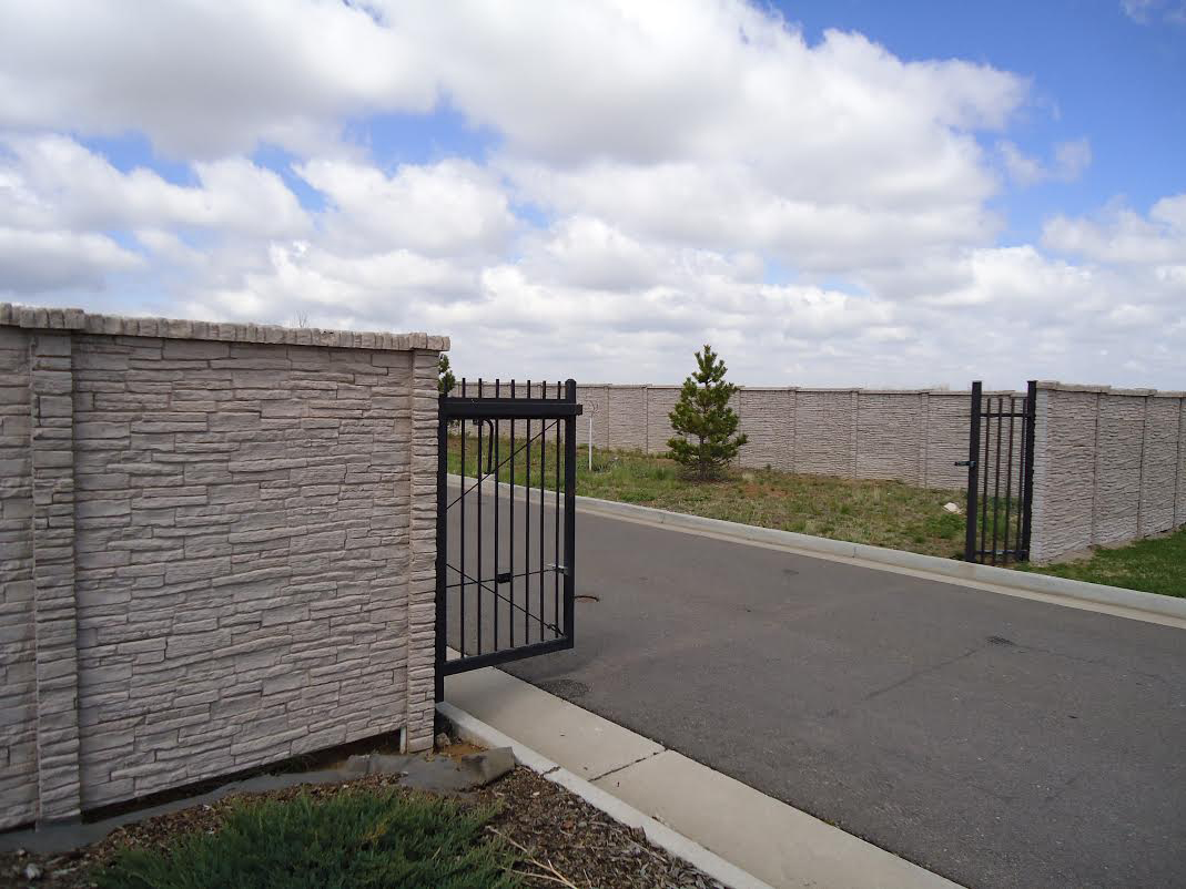 Concrete fence with black moving gate